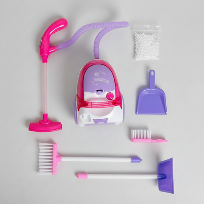 Children's toy cleaning set with vacuum, broom, and dustpan on a flat surface